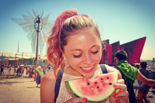 Girl eating a watermelon at Lightning in a Bottle Festival